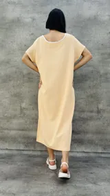 Vestido largo blanco con mangas cortas negras y corte holgado.