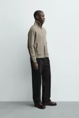 Chaqueta regular fit de tejido técnico interlock de algodón elástico, color azul marino. Presenta cuello subido, manga larga, bolsillos de vivo en la cadera, acabados en rib y cierre frontal con cremallera.