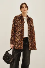 Tapado tipo sobrecamisa con estampado animal print, de corte recto y largo a la cadera. Presenta cuello camisero, cierre frontal con botones y dos bolsillos frontales con solapa.