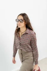 Camisa de crepe con estampado geométrico de hexágonos en tonos bordó, marrón y blanco. Presenta cuello camisero clásico, cierre frontal con botones y mangas largas con puños abotonados.