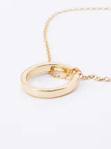 Cadena fina de eslabones con dije circular minimalista en tono dorado.