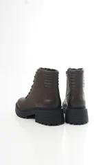 Borcegos de cuero color chocolate, con cordones frontales, cierre lateral y suela track con taco ancho.