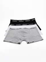 Pack de tres boxers de algodón con cintura elástica personalizada con el logo de la marca. Incluye un boxer negro, uno blanco y uno gris melange.
