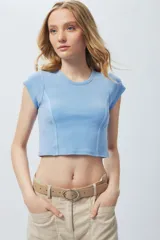 Top corto ajustado de manga corta, color azul celeste, con cuello redondo y costuras verticales que definen la silueta.