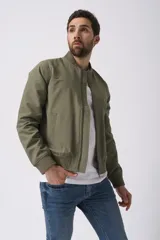 Campera bomber verde oliva con cuello, puños y cintura acanalados. Cierre frontal con cremallera y bolsillos laterales.