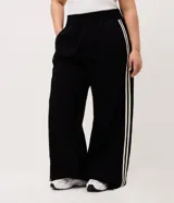 Pantalón pantalona negro de algodón, de corte amplio y cómodo con cintura elástica. Presenta franjas laterales a contratono de diseño deportivo.