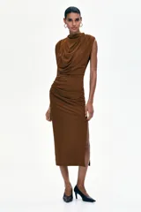 Vestido midi en punto elástico marrón, con cuello drapeado alto, hombreras y diseño sin mangas. Presenta frunces en los hombros y en la cadera con falda entallada.