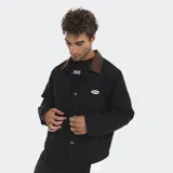 Campera estilo carpenter color beige con cuello de pana en contraste color marrón. Presenta cierre frontal con botones metálicos, bolsillos frontales con solapa y parche bordado con logo en el pecho. El interior cuenta con forro acolchado.