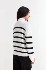 Sweater de punto con cuello alto, diseño de rayas horizontales en color blanco y negro, mangas largas y corte holgado.
