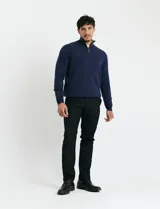 Remera de punto con medio cierre frontal, manga larga y cuello alto. Presenta puños y cuello en tejido canalé, con cierre metálico y detalles en contraste en el interior del cuello.