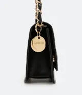 Bolso pequeño estructurado color negro, con textura capitoneada, asa de cadena y solapa frontal con botón a presión. Incluye divisor interno con cremallera.