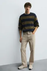 Pantalón de corte recto confeccionado en tejido de algodón con elasticidad. Presenta diseño de cinco bolsillos, cierre frontal con cremallera y botón.