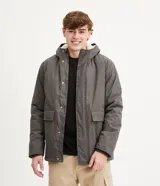 Campera pesada de hombre, color gris jaspeado, con capucha forrada en sherpa color crema. Presenta cierre frontal con botones a presión y dos bolsillos frontales con solapa.