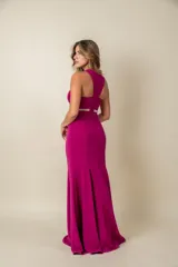 Vestido largo de fiesta fucsia, corte sirena, con escote halter y detalles de tul transparente en el cuello y la cintura.