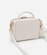 Bolso transversal tipo camera bag, color blanco con textura matelasse de rombos. Tiene correa fina ajustable y removible, cierre de cremallera y colgante de pompón.