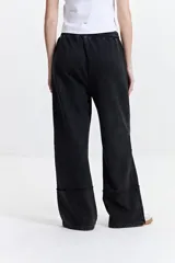 Pantalón de felpa negro con cintura elastizada ajustable, bolsillos laterales y corte acampanado.