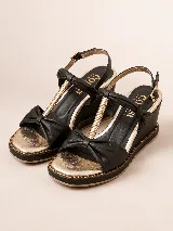 Sandalia de plataforma corrida color negro con detalles dorados, confeccionada en cuero con tiras acolchadas, detalle metálico en el empeine y tira ajustable con hebilla al tobillo.