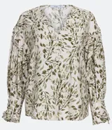 Blusa de crepé color blanco con estampado de hojas verdes, escote en V y mangas largas abullonadas con detalle de nudo en los puños.