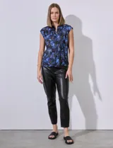 Blusa de satén estampado con flores azules y marrones, marca Elie Tahari. Tiene cuello a la base, escote en V y abertura central con botones ocultos.