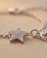 Pulsera de cadena plateada con dijes colgantes de corazón y estrella con incrustaciones de circones.