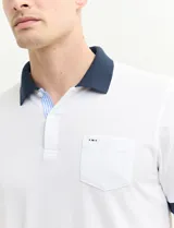 Remera manga corta color verde con cuello polo y bolsillo en el pecho. El cuello y los puños son de color azul marino.