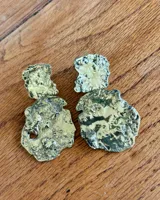 Aros colgantes de bronce con forma irregular y textura rugosa.