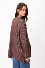 Sweater de tejido artesanal con diseño de rayas verticales en tonos camel y beige, corte holgado, cuello redondo y puños altos ajustados.