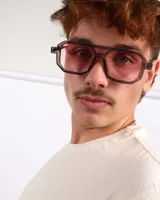 Lentes de sol unisex con montura geométrica color marrón y cristales rosados. Ofrecen protección UV400.