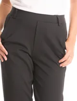 Pantalón de vestir negro de corte recto, con cintura elástica ancha y bolsillos laterales funcionales. Presenta un diseño minimalista sin cierres ni botones, con bolsillos traseros tipo ojal simulados.