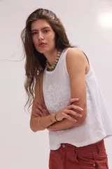 Musculosa de lino blanca con sutiles detalles bordados en el frente, corte holgado y escote redondo.