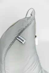 Bandolera color gris claro con forma de media luna, cierre de cremallera y correa ajustable. Incluye etiqueta metálica con el logo de la marca.