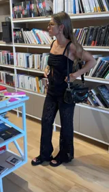 Pantalón largo de encaje negro, de corte recto y tiro alto.