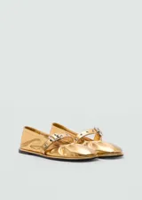 Zapato tipo bailarina de color dorado con acabado metalizado, punta redonda y detalle de tira con hebilla metálica en el empeine.