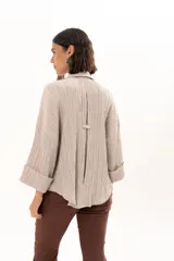 Camisa de silueta relajada con cuello clásico, confeccionada en tela liviana con textura. Presenta mangas amplias con caída fluida y un tablón escondido en la espalda que aporta mayor amplitud al calce.