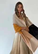 Pashmina de tejido de punto fino con diseño de bloques de color en tonos beige, mostaza, negro y marrón claro.