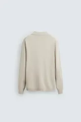 Polo de punto regular fit en color beige, confeccionado con una mezcla de algodón y cáñamo. Presenta cuello solapa con abertura frontal, manga larga y acabados en rib.