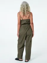 Mono largo color verde militar, con breteles finos, escote en V, cierre frontal con botones, cinturón con hebilla metálica, bolsillos laterales y corte holgado.