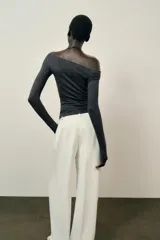 Top de manga larga confeccionado en tejido de algodón, con diseño de escote asimétrico y corte ajustado al cuerpo.