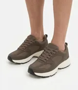 Championes deportivos Renner de color marrón, con diseño robusto y capellada que combina material sintético liso y paneles de malla respirable. Cuentan con cordones tono sobre tono, suela gruesa de goma en color blanco y detalles negros en la parte inferior.