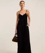 Vestido largo de corte evasé confeccionado en crepé color verde oliva. Presenta escote corazón, breteles finos ajustables, espalda con lastex y tajo lateral en el ruedo.