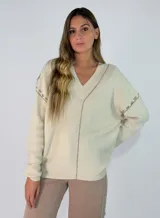 Sweater de tejido de punto color beige, con cuello en V y costuras decorativas visibles en tono contrastante a lo largo del frente y en las mangas.