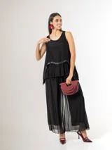 Pantalón de seda italiana con forro de viscosa elastizada, de corte holgado y diseño fluido, con detalles de paillettes en los costados y cintura elastizada.