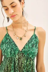 Top bretelero de gasa con estampado de reptil en tonos verdes. Presenta un diseño fluido con escote en V, breteles finos y elástico en la espalda para un mejor ajuste.