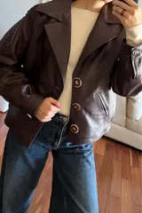 Campera bomber de cuero color vino, con cuello de piel sintética desmontable y corte oversized.