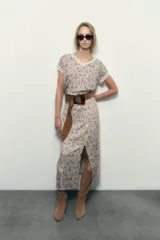 Falda midi estampada con motivos arabescos en tonos beige, celeste y marrón. Presenta tajo frontal y cintura elastizada.