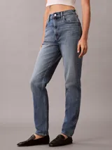 Jeans mom fit de tiro alto y pierna cónica, en denim azul con efecto deslavado. Cuenta con diseño clásico de cinco bolsillos, cierre de botón y cremallera, y detalles distintivos de la marca Calvin Klein.