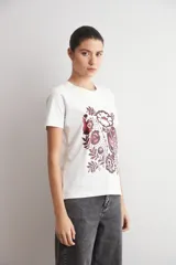 Remera blanca de manga corta con estampa damasco floral en tonos bordó y negro en el frente.
