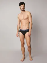 Pack de tres slips Calvin Klein de color negro, confeccionados en mezcla de algodón y elastano. Cuentan con talle medio y una distintiva cintura elástica con logo de la marca en colores azul marino, blanco y verde.