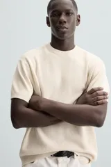 Camiseta negra de punto perlado, corte regular fit, cuello redondo, manga corta y rib en los acabados.