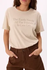 Remera color beige de algodón suave, con corte relajado y estampa frontal con la frase “The Earth Needs All The Friends It Can Get”.